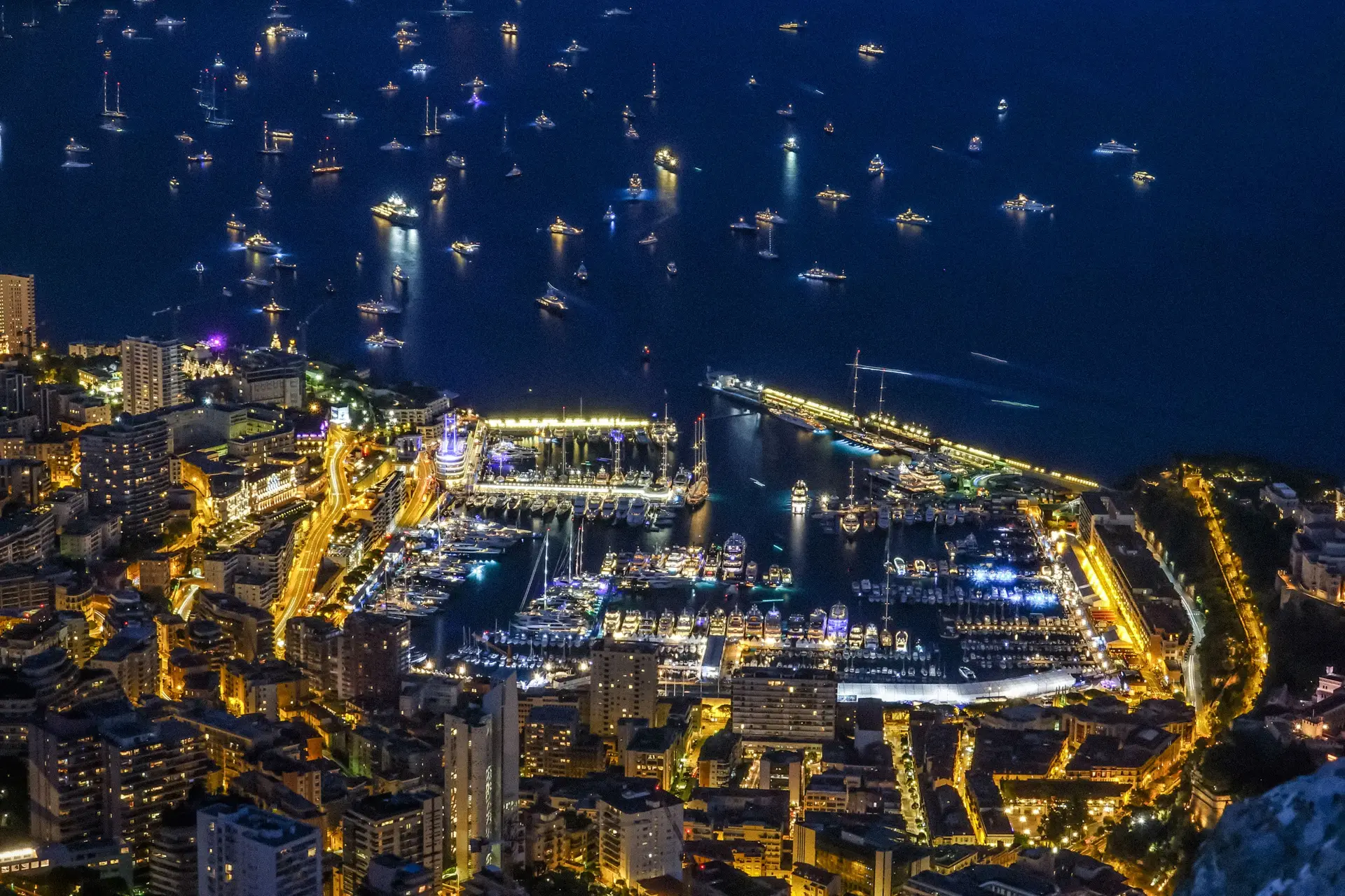 Panoramautsikt over Monaco kysten og opplyst resortmiljø om natten